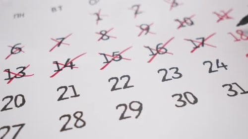 Hand Crossing out Dates on Calendar with Pen