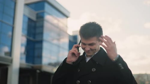 Smiling Young Adult Talking on Cell Phone Outside