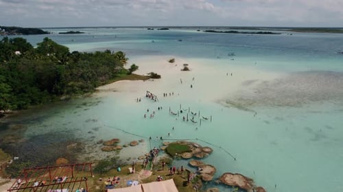 4K drone footage of people pn vacation having fun on the beach. Stock footage of a beachfront destin