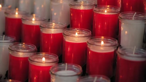 A Bunch of Red and White Candles are Lit Up in a Row