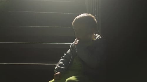 Child Sitting on Dark Stairs at Night