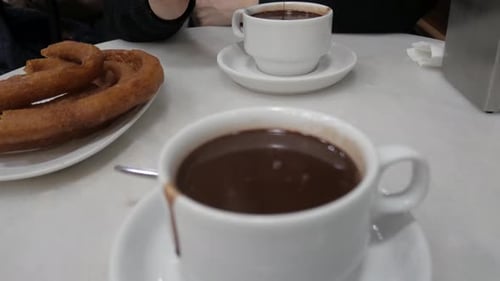 Cozy Café Scene in Madrid with Hot and Churros Delight