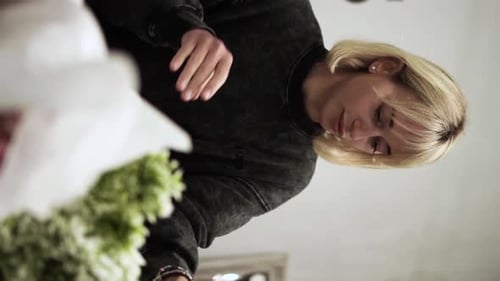 Awesome florist girl working in flower shop, preparing flowers for sale, vertical video ES