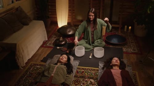 Sound Healing Practitioner Playing Singing Bowls and Wind Chime for Guests