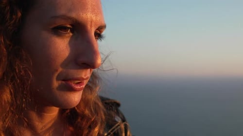 Profil de femme au coucher du soleil, femme regardant la vue pendant l'heure dorée à l'extérieur