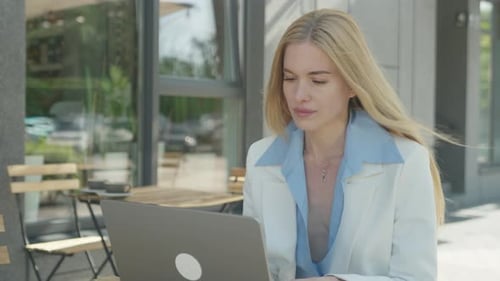 Modern Businesswoman Working Thoughtfully At Outdoor City Cafe