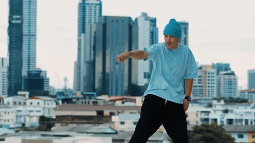 Erfahrener kaukasischer B-Boy-Tänzer übt Straßentanz auf dem Dach. Hip-Hop.