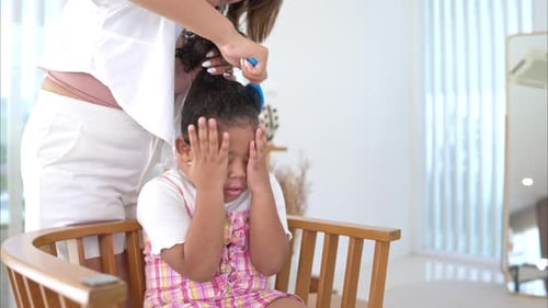 Parent Brushing Child's Hair Indoors