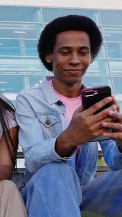 Young Adult Uses Mobile Phone With Friends