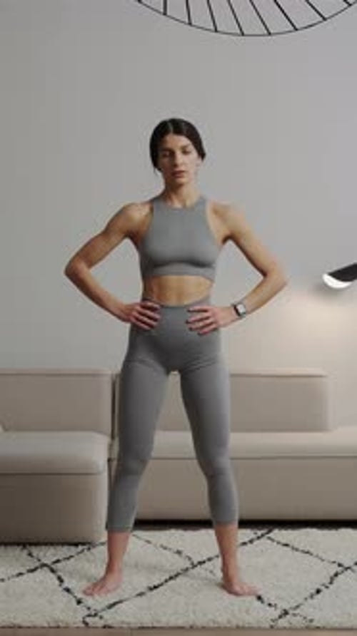 Woman in Gray Activewear Stretching Neck at Home