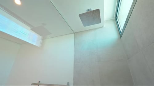 Moderne Badezimmereinrichtung mit minimalistischem Design, die Armaturen wie ein Duschtuch zum Vorschein bringt
