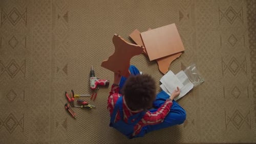 Top View of African American Woman Reading Instruction to Assemble DIY Furniture
