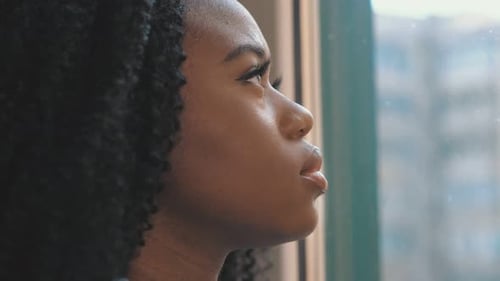 Woman Gazing Out Window in City Setting