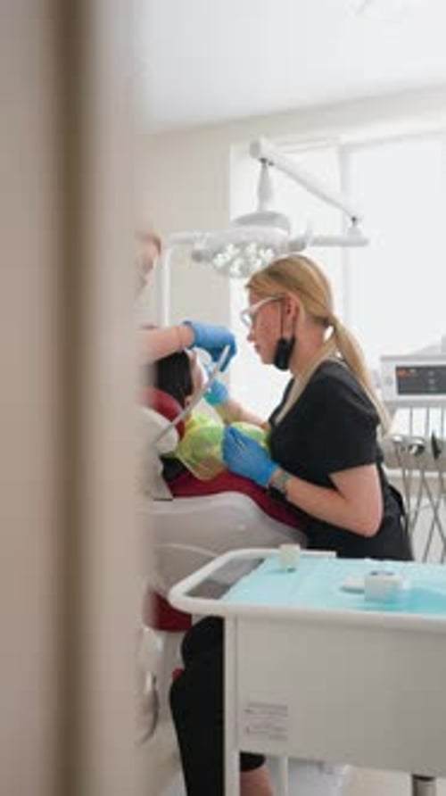 Woman Dentists Doing Teeth Cleaning Procedure Female Patient in Dental Office