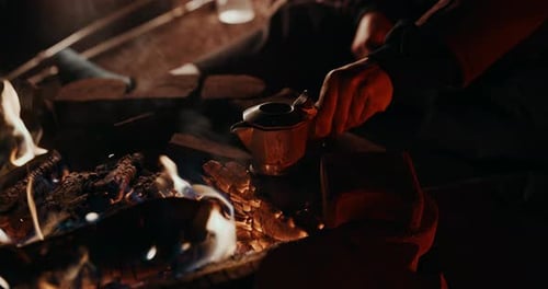 Café de fogata: un joven con la pierna enyesada pone su destartalada cafetera de moka en la brasa de su coche