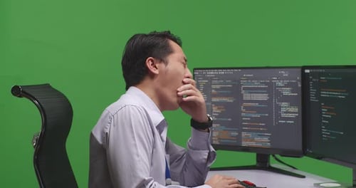 Developer Yawning Before Sleeping While Write Code With Multiple Computer Screens In Green Screen