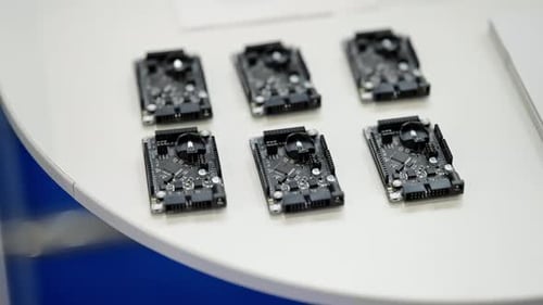 Nahaufnahme von sechs kompakten Mikrocontroller-Entwicklungsboards, die übersichtlich auf einer weißen Tischplatte angeordnet sind