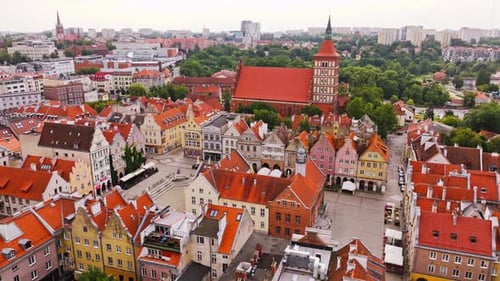 Survol d'un Drone cinématographique révélant les toits et la place centrale de la vieille ville d'Olsztyn