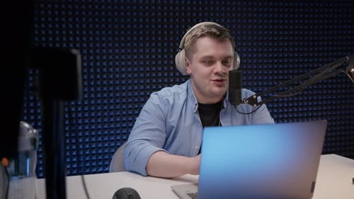 Radio Host Sit in Studio and Communicates with Audience Man in Blue Shirt and Headphones Sits in
