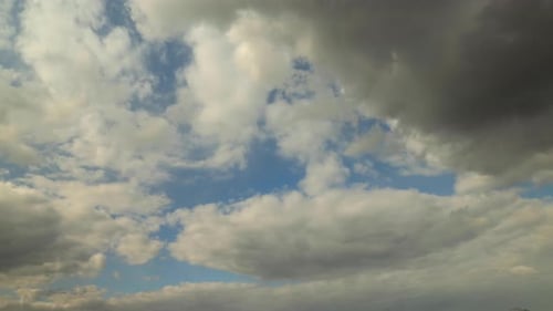 Time lapse of thick and fluffy clouds forming against a blue sky with turmoil of growing and