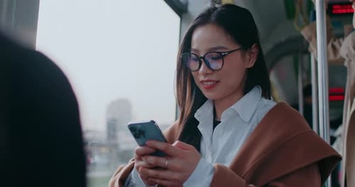 Woman Using Smartphone on Public Transportation