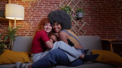 Smiling Women Embracing on a Couch