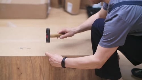 Man Using Hammer to Assemble Furniture