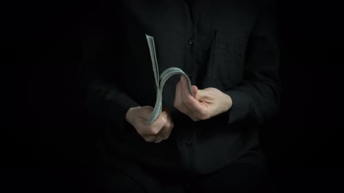 Businesswoman with Bundle of Dollars on Black