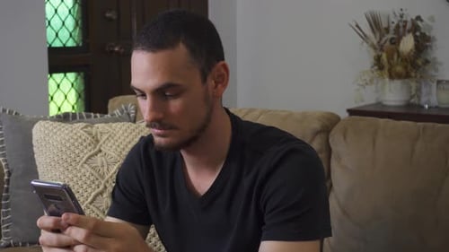Young Adult Using Phone While Relaxing on Couch