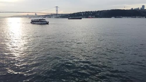 aerial near twilight moving toward a water ferry on the Bosphorus strait in Istanbul Turkey. Scenic