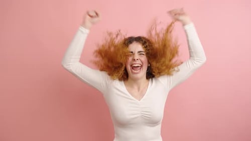 Young Woman Expressing Joy and Excitement in Studio Setting
