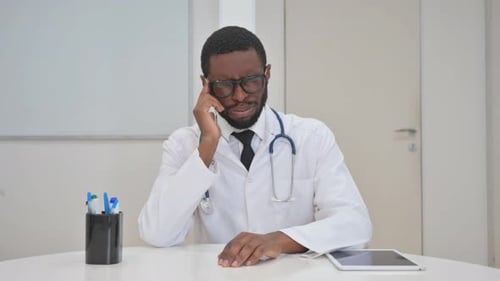 Doctor with Headache at Desk in Bright Office