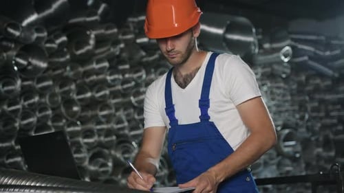 Man in uniform works on the production. Industrial modern technology