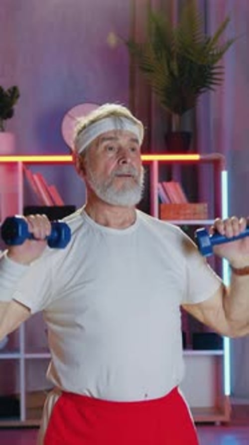 Senior Man Lifts Dumbbells During Workout At Home