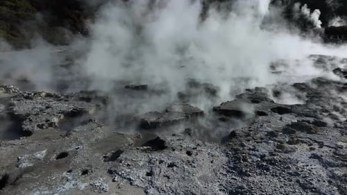 Drone slowly flying over geothermal landscape with bubbling mud and steam. Alien Landscape. Sci-fi.