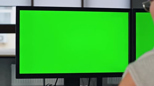Gros plan de l'écran du PC vert Manager Working. Deux moniteurs Chromakey au bureau à domicile