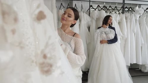 Duas noivas felizes escolhem seu vestido de noiva no salão de casamento