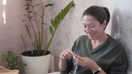 Young Woman Knitting at Home