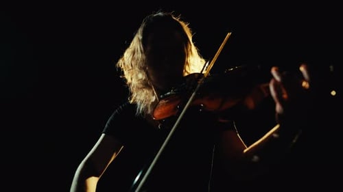 Violinist plays a solo performance in the dark