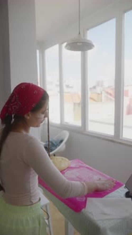 Une femme prépare habilement la pâte dans sa cuisine lumineuse remplie de soleil