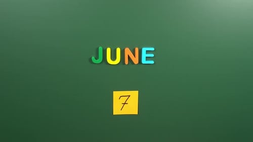 Hand sticking a sticker 7 June calendar day on school board. 7 date of June. Seventh day June