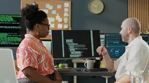 Multiethnic Programmers Talking while Coworking in Open Space Office