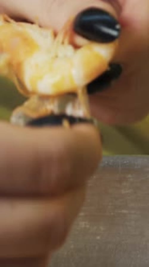 young woman cleans big boiled shrimp close up Vertical video.