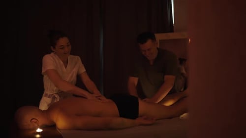 Two Massage Therapists Giving Massage to Man