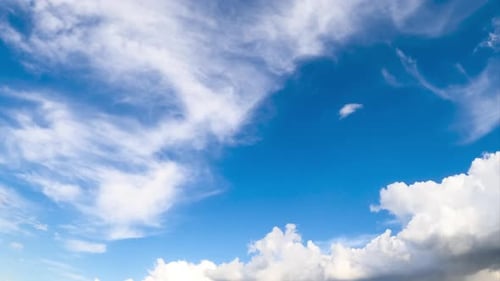 Azure skies with floating soft light clouds. Summer day cloudscape from low angle view. Timelapse.