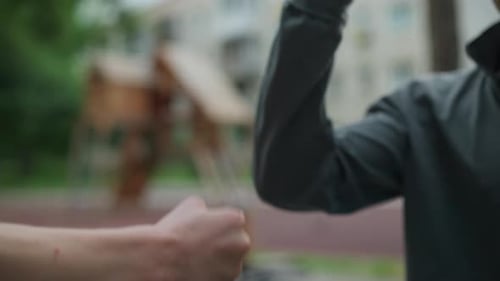 Two Arms Connect Fists in Urban Setting