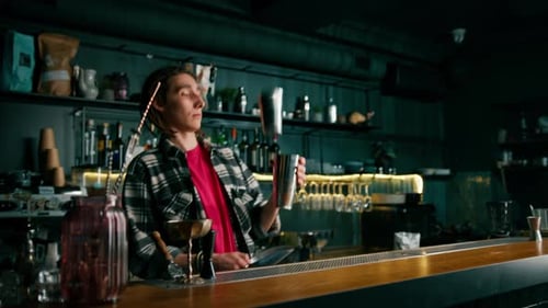The bartender throws ice into the shaker the first steps in making a cocktail a cocktail the bar