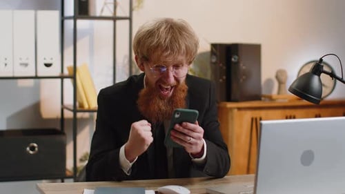 Excited Businessman Celebrates Good News on Phone