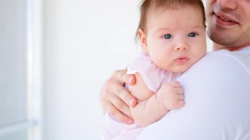 Caring Father Holding Infant in Home Interior