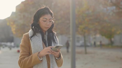 Woman Using Smartphone in Urban Park Setting